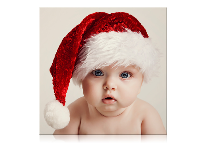 Impresión en lienzo de un bebé con gorro de Navidad.