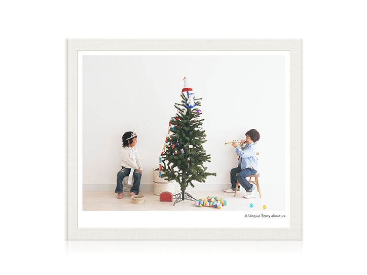Klassisches Fotobuch mit spielenden Kindern am Tannenbaum auf dem Cover.