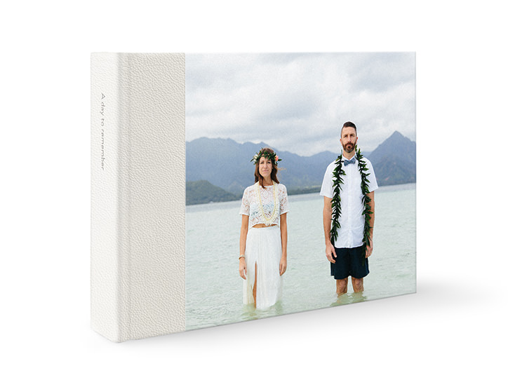 Album fotografico premium in pelle bianca con coppia di fidanzati in piedi nell'acqua.