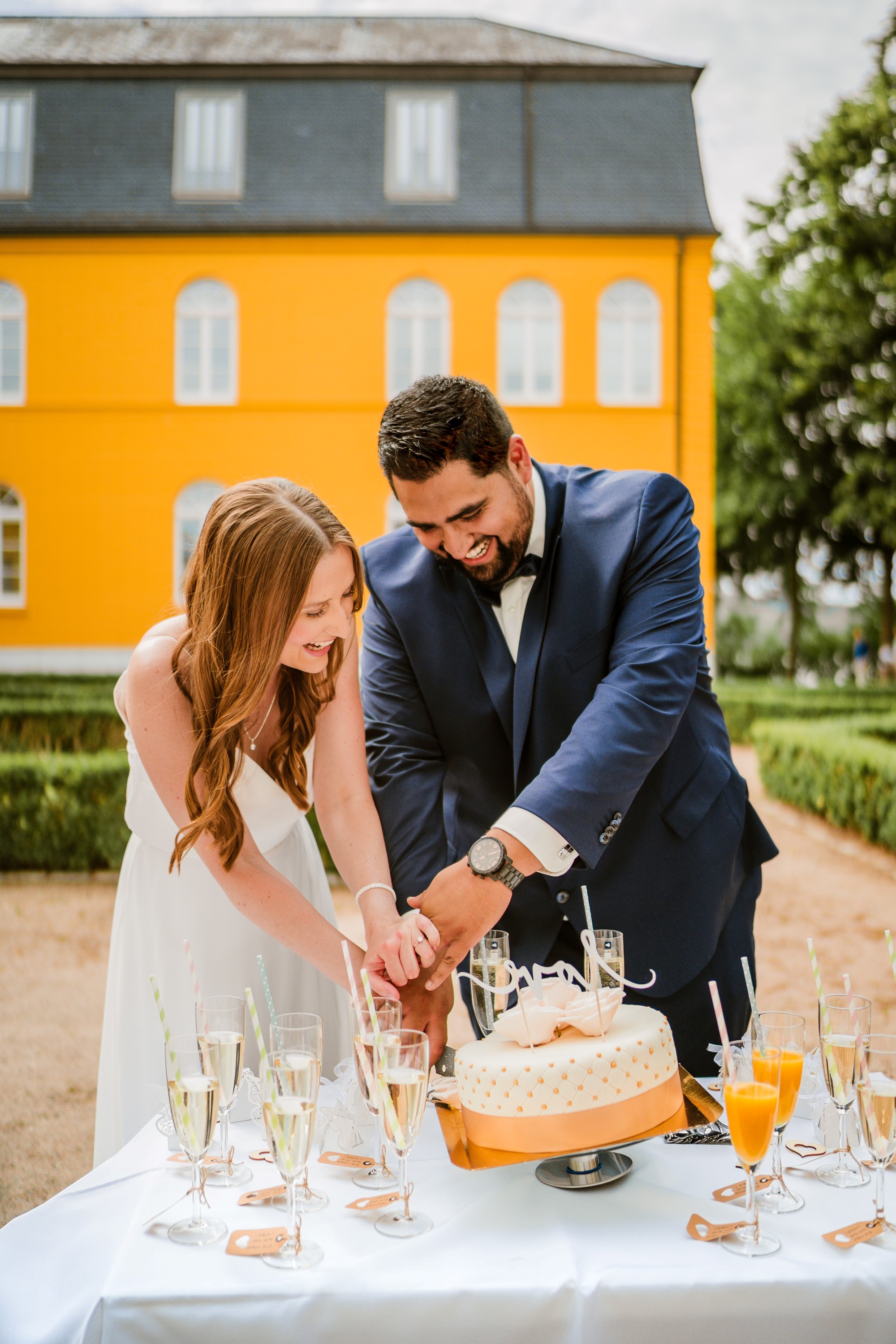 Brautpaar schneidet Hochzeitstorte an.