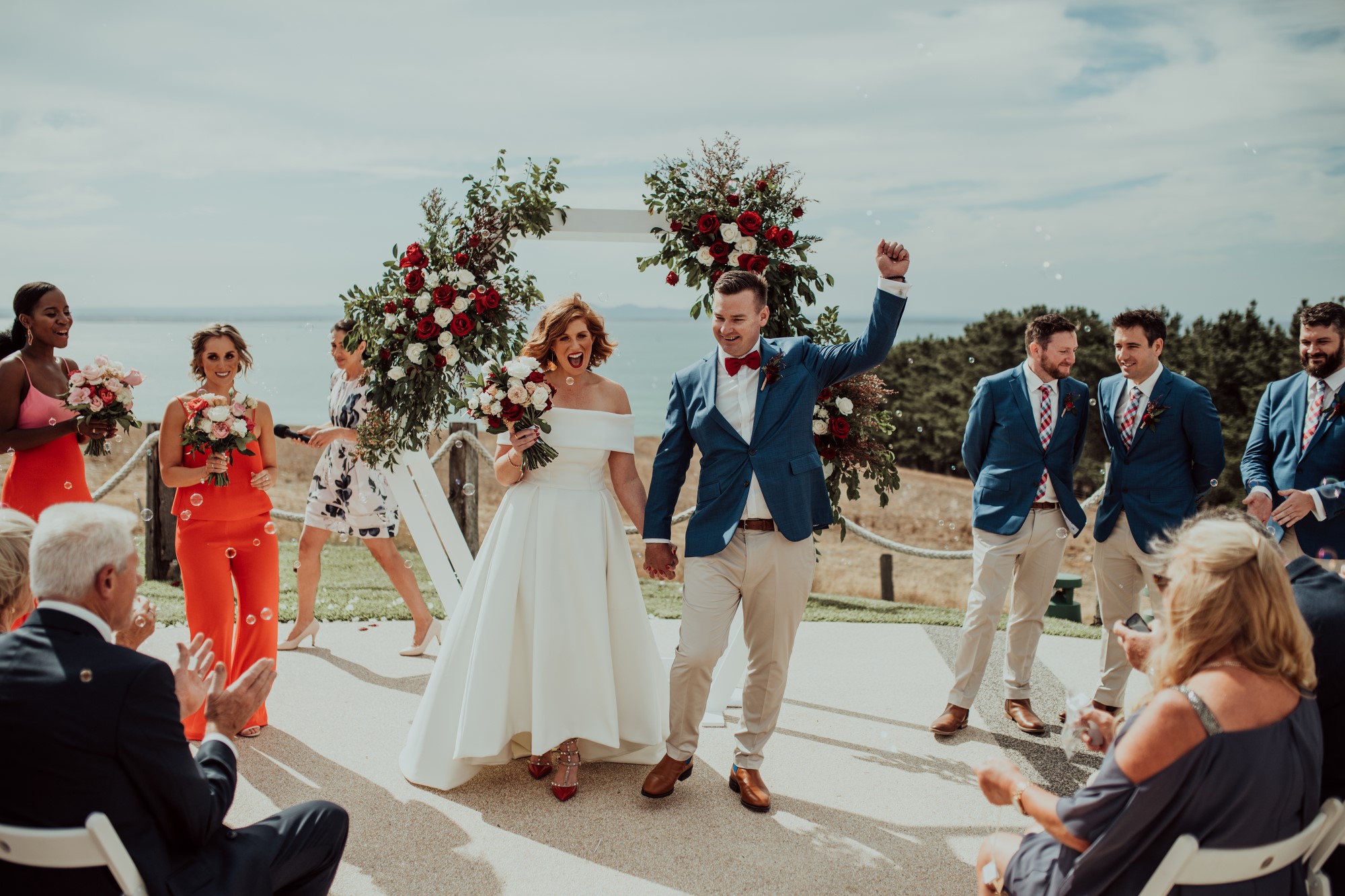 Bride and groom walking down wedding aisle happily