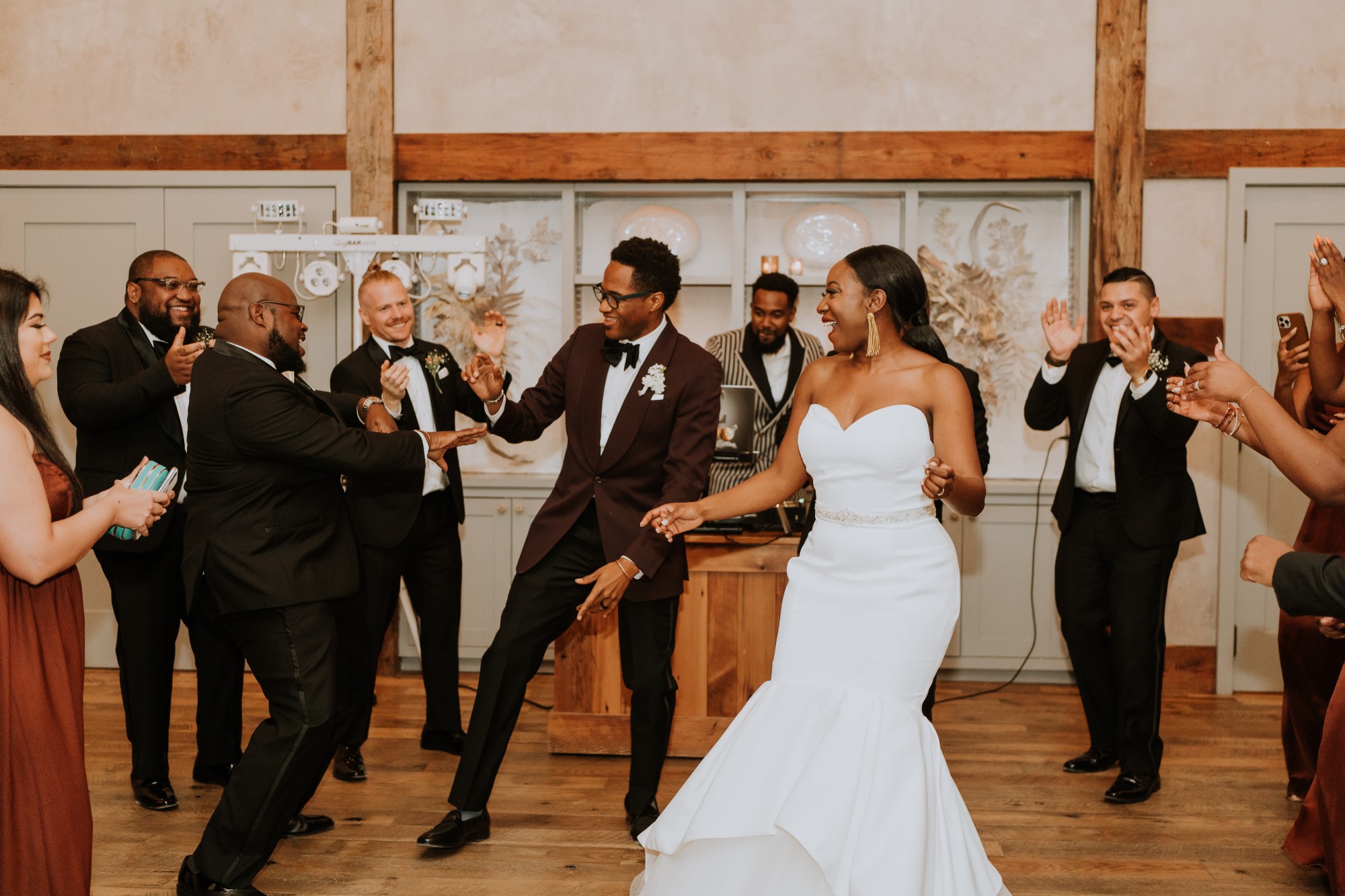 Bridal couple dancing at wedding reception with friends and family