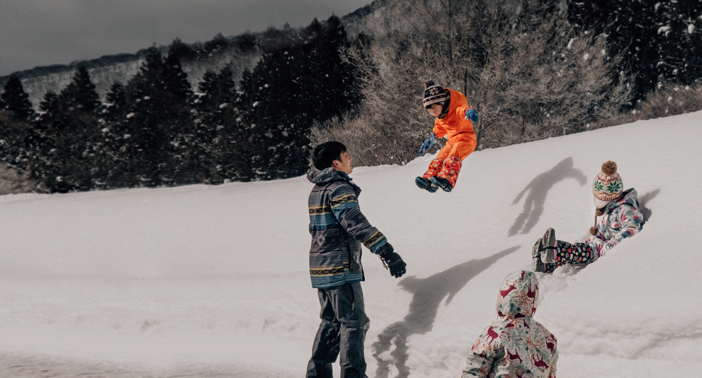 Quatro crianças brincam na neve.