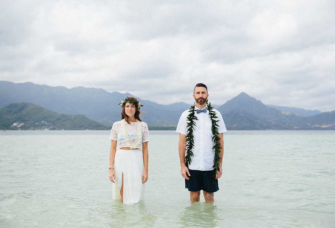 Couple standing in water on wedding day.