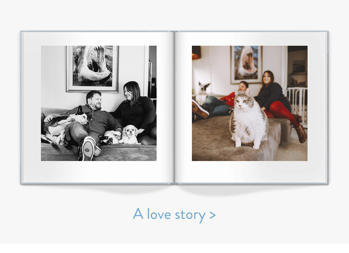 Open photo book with couple sitting in their living area with their pet dogs and cat