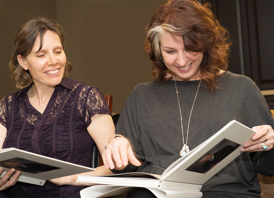 Two women looking through MILK photo books.