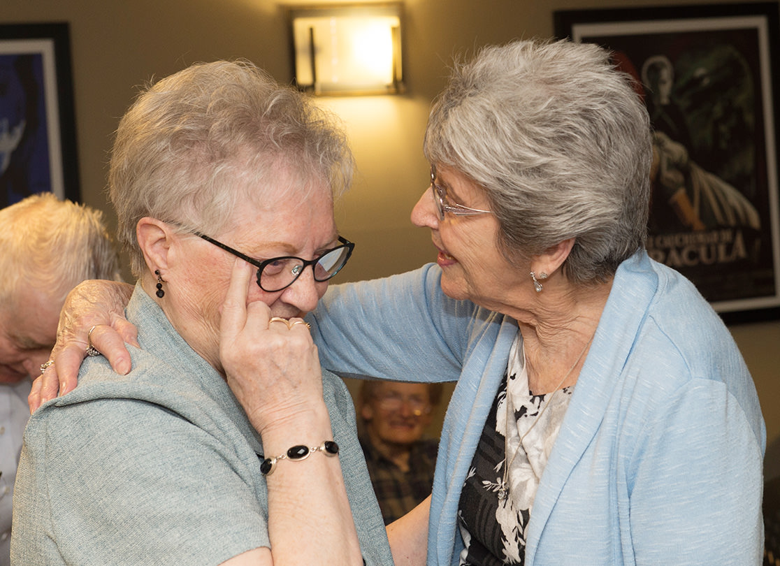 Two older women embracing.