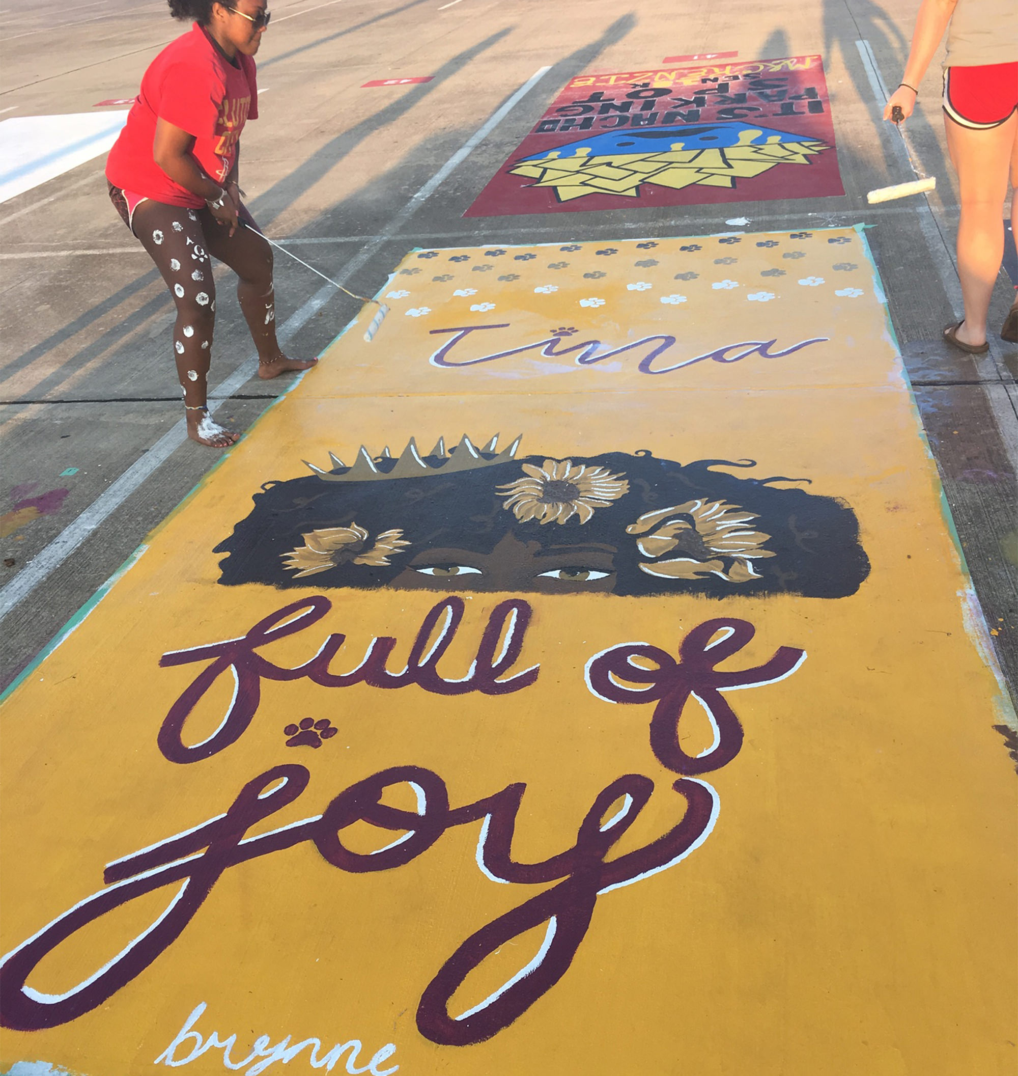 Woman painting art on the sidewalk.