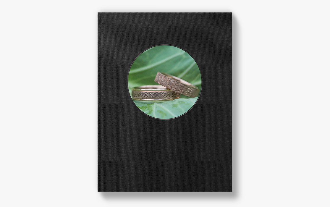 Photo book with two wedding rings on the cover.
