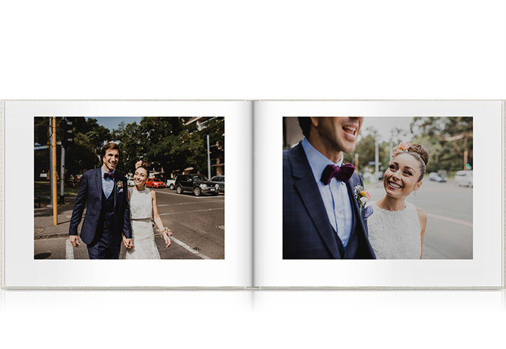 Aufgeschlagenes Fotobuch mit verliebten Hochzeitspaar auf den Seiten.