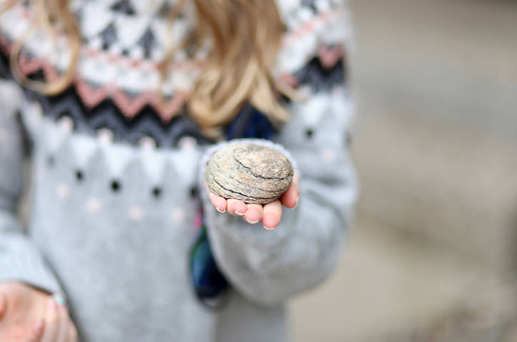 Girl holding rock from the beach.