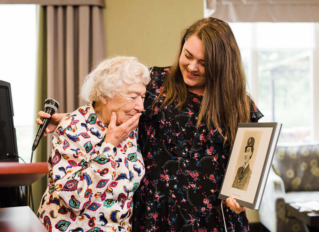 Jean Perdue looking at a younger portrait of herself.