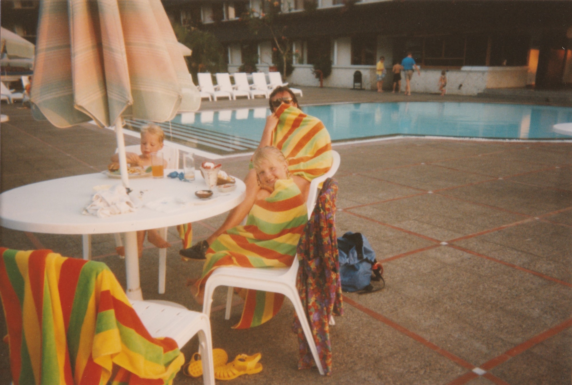Old photo of family dining poolside.