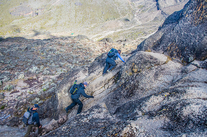 People climbing up a rocky mountainside.