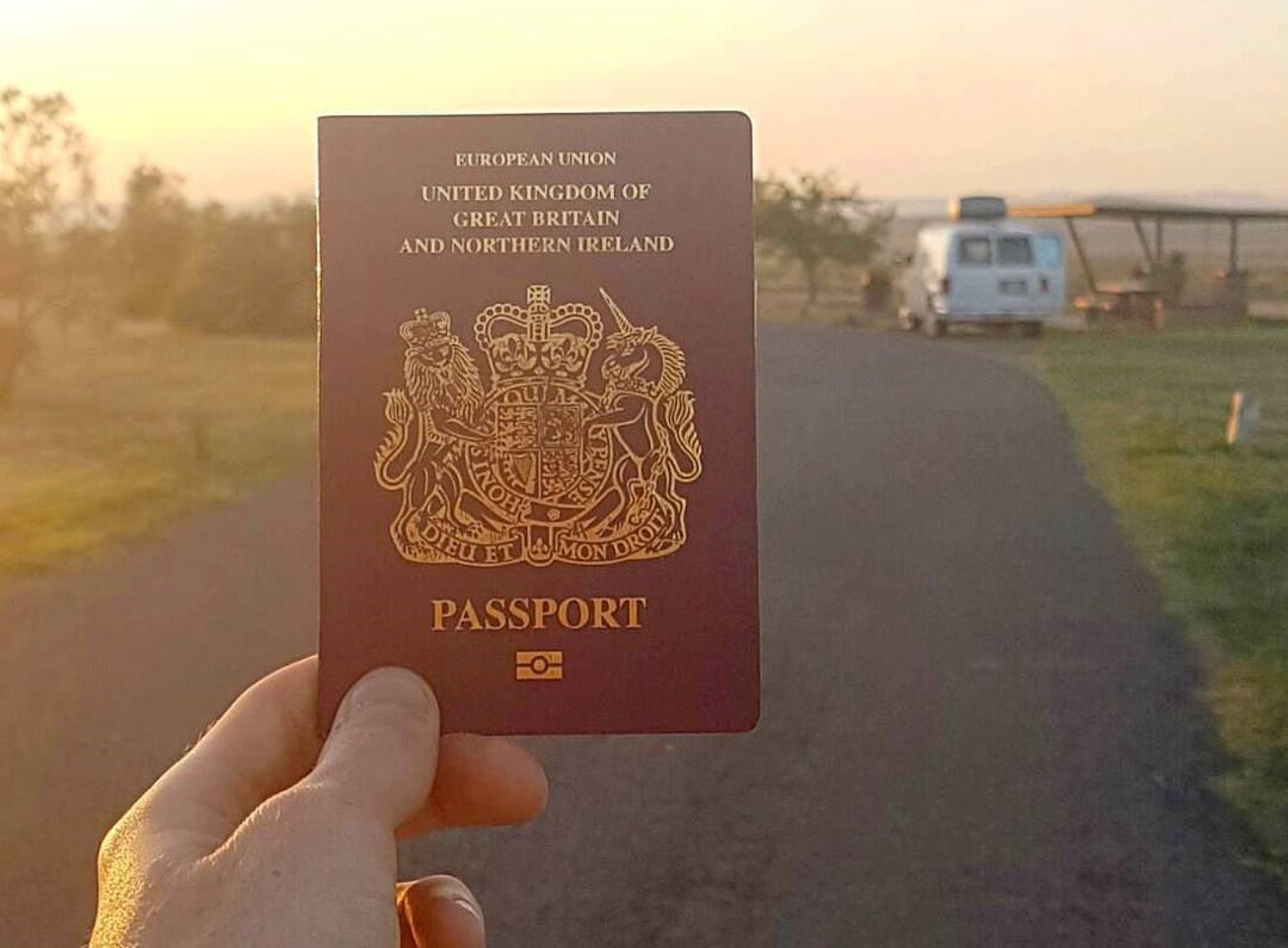 Hand holding a UK passport.