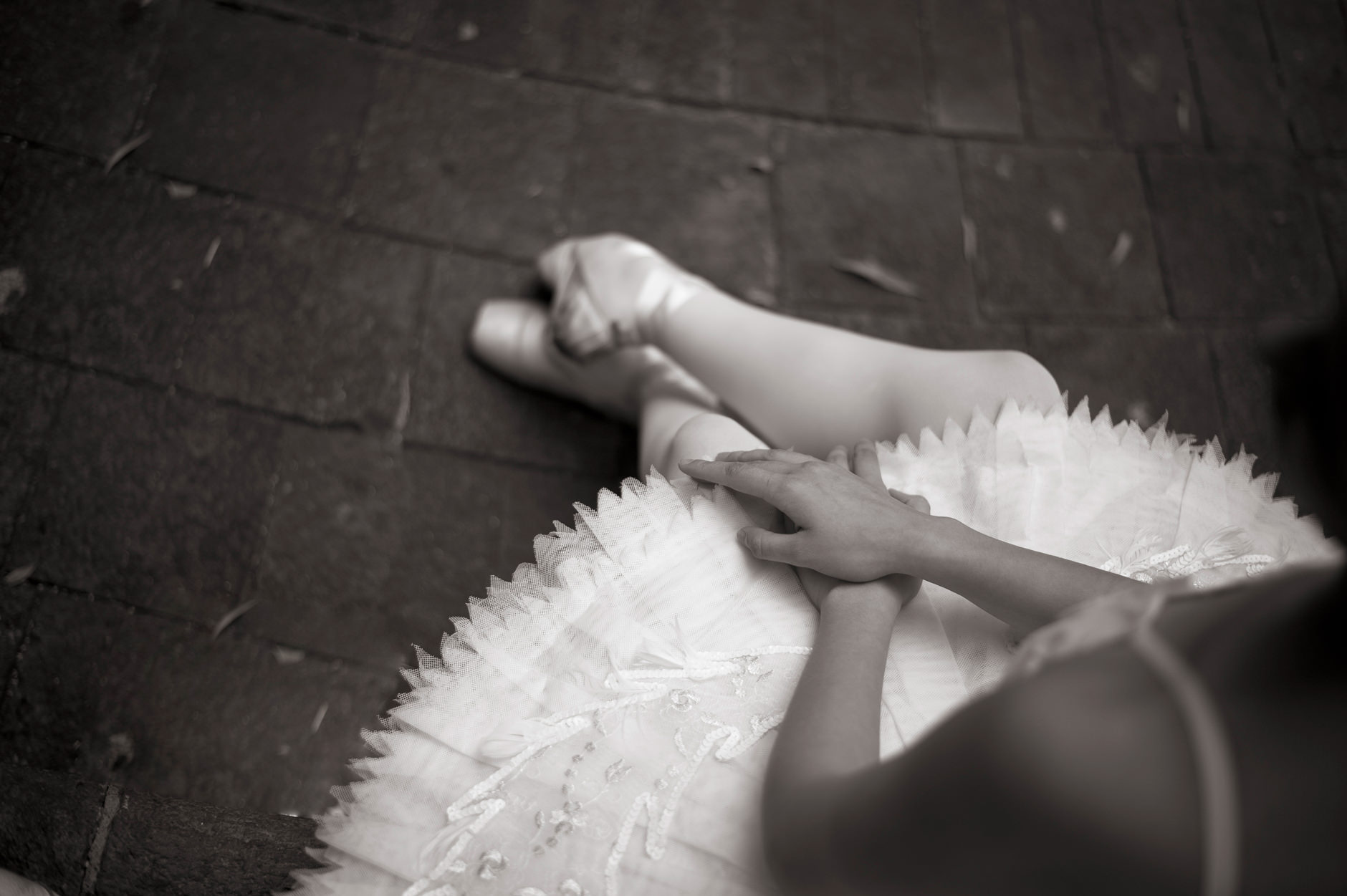 Ballet dancer's hands crossed over her tutu.