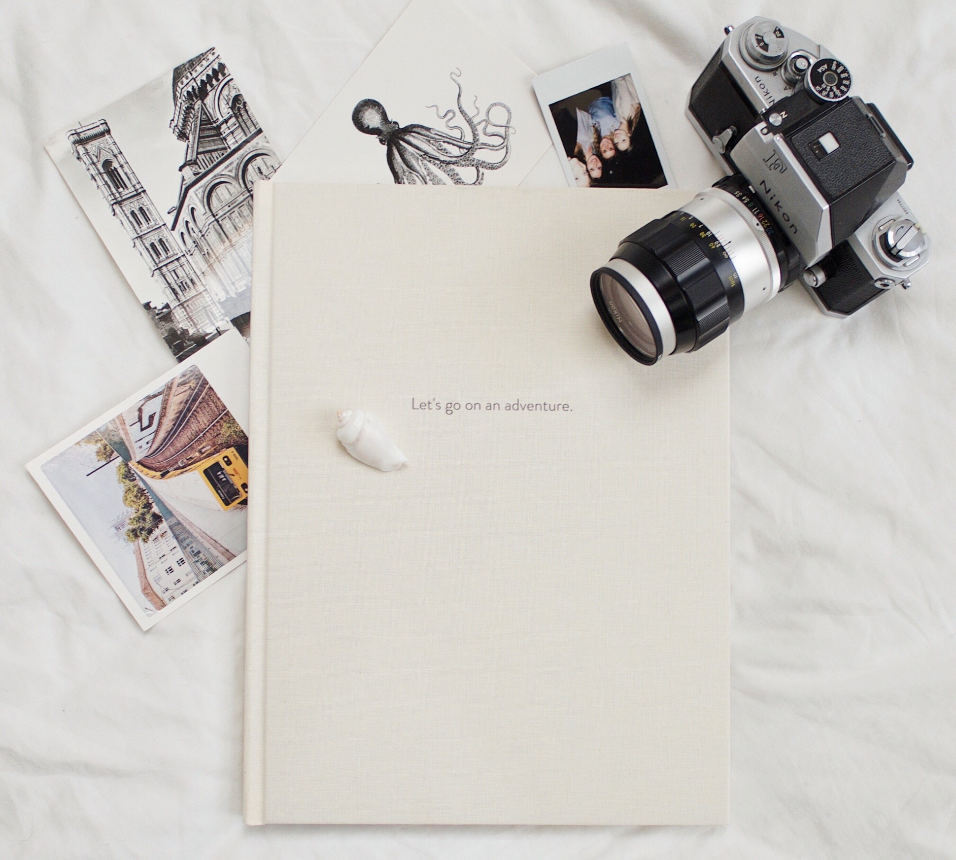 Flatlay of camera, photo book and sketches.