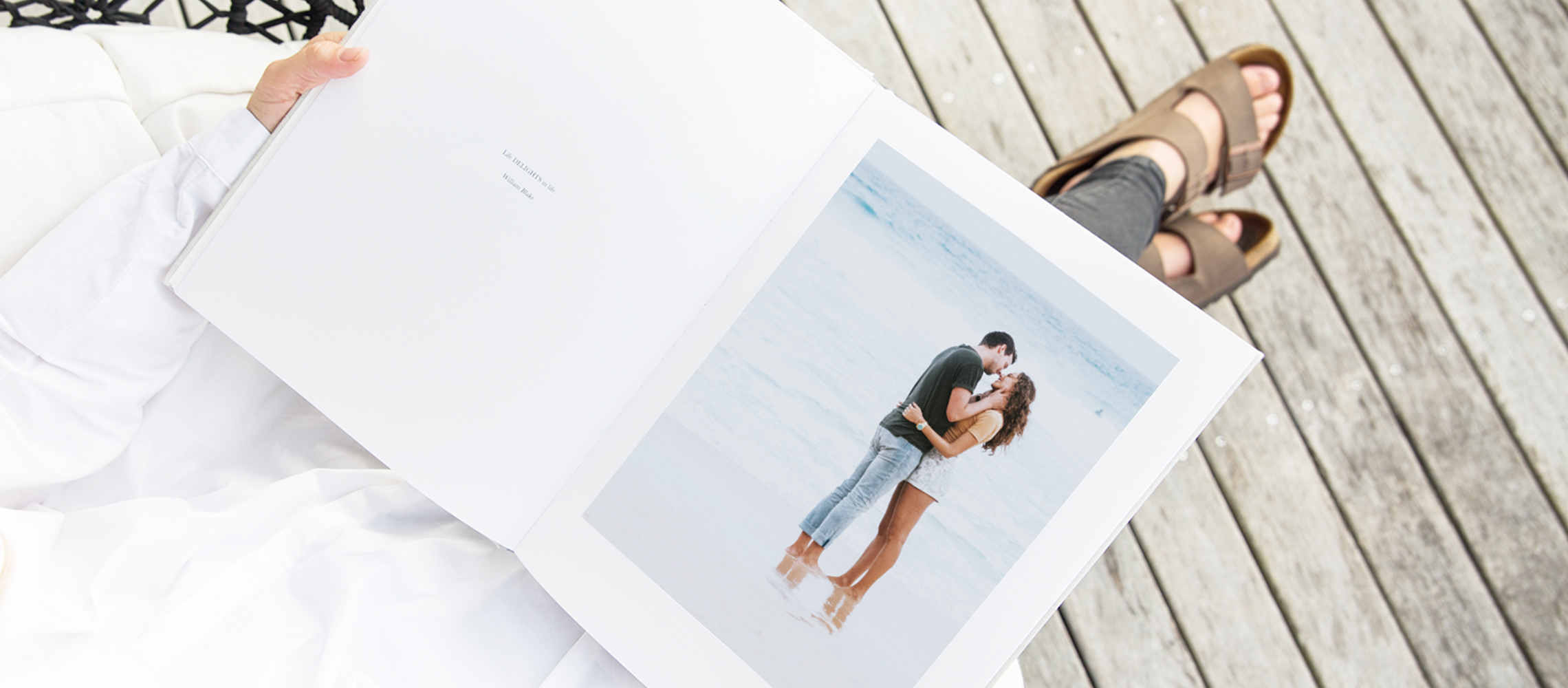Álbum de fotos abierto con la imagen de una pareja besándose en la playa.