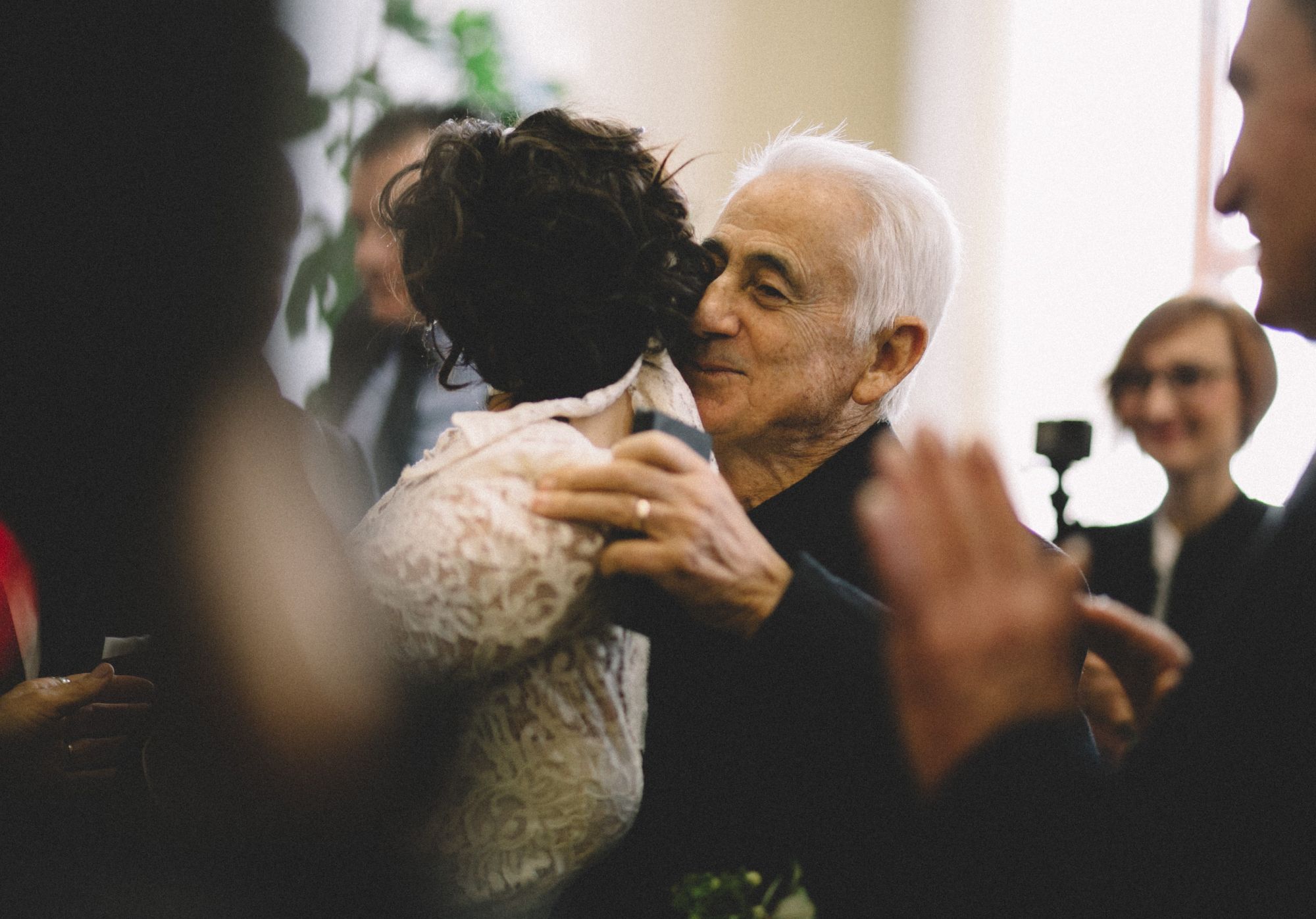 Man kissing bride on the cheek.