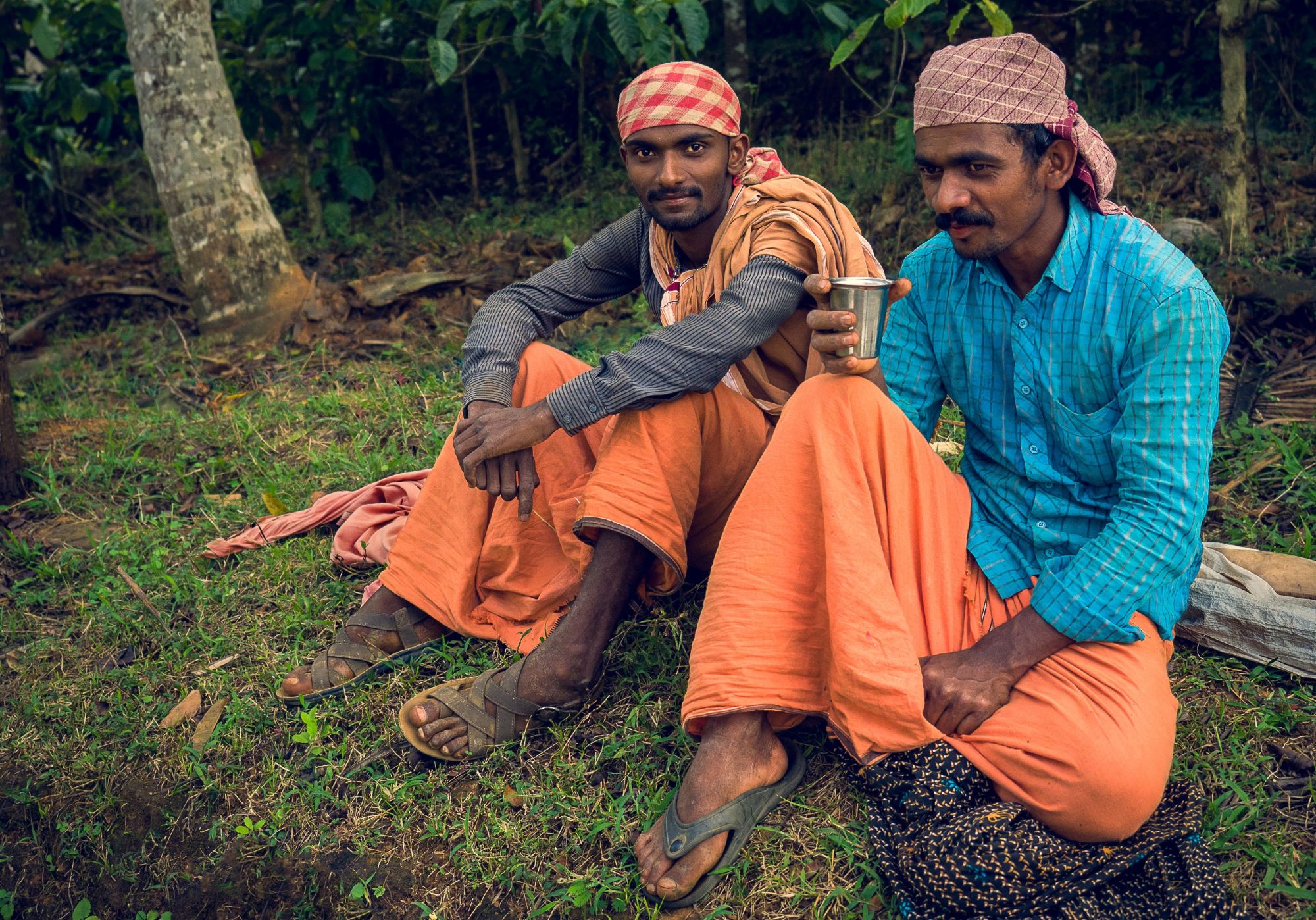 Two men sitting on the grass.
