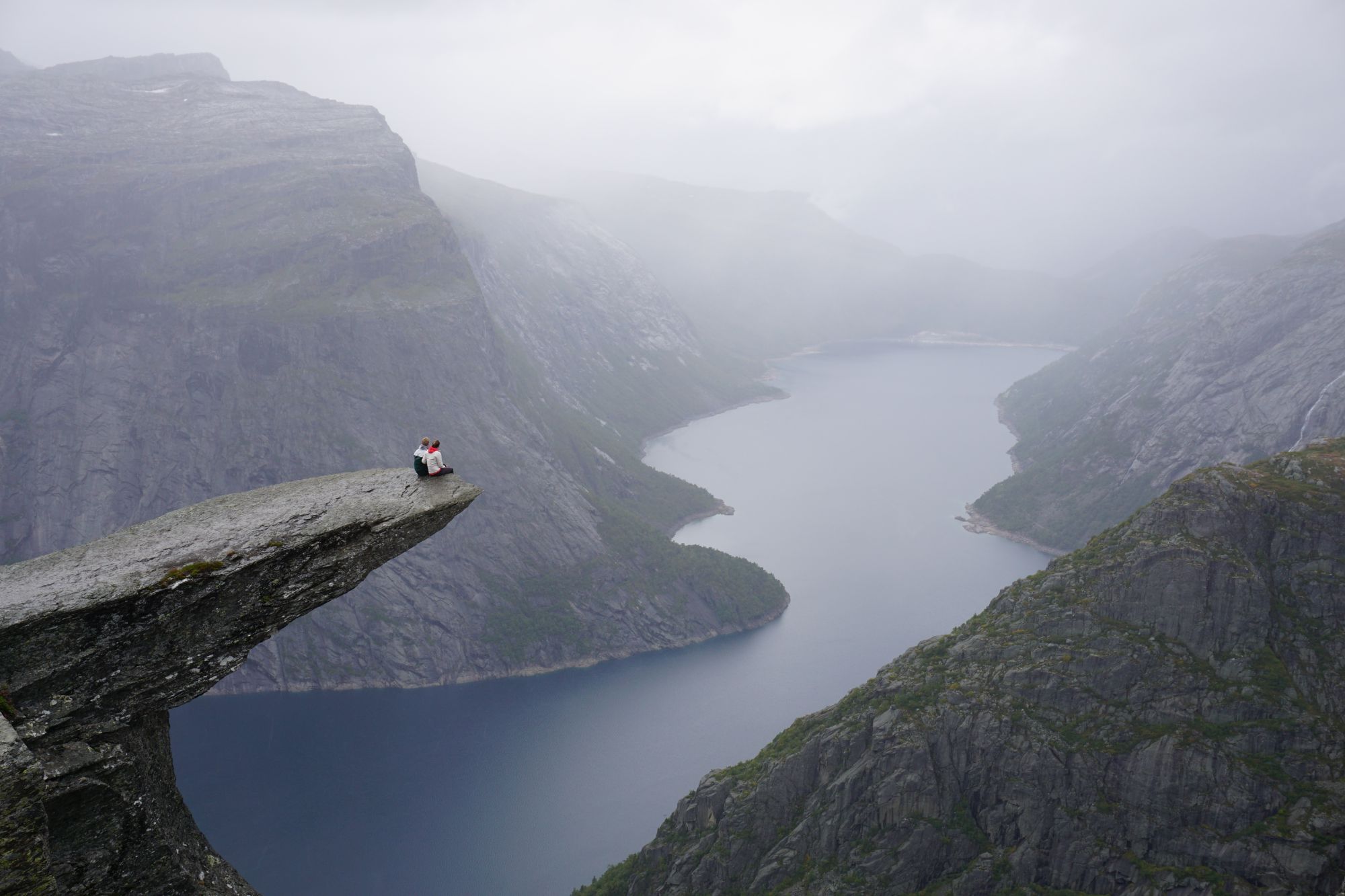 Couple sat on Pulpit rock in Norway.