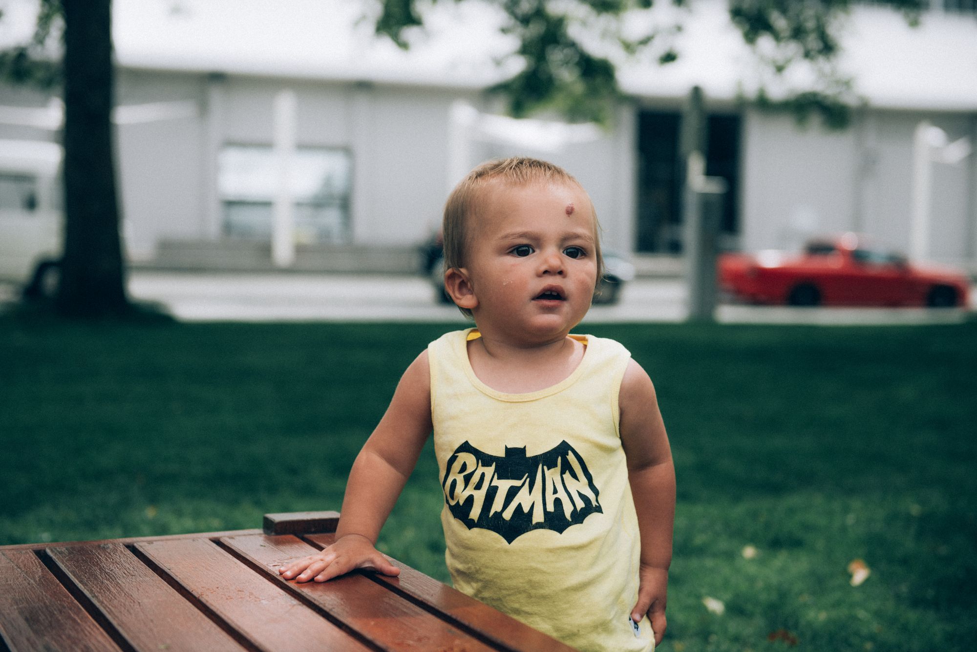 Toddler outside in a yellow singlet.