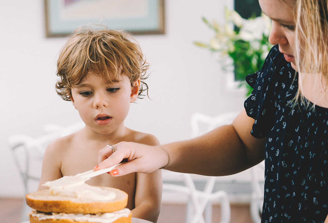 Mother and son icing a cake
