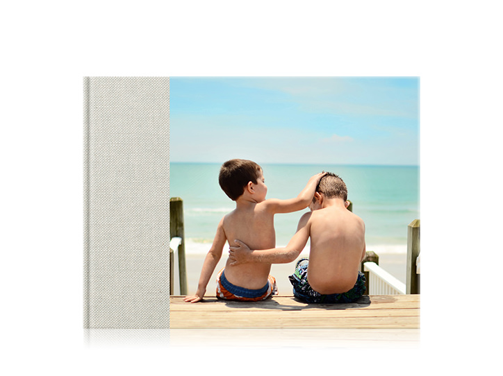 Livre photo de famille premium paysage avec une couverture 3/4 de deux frères à la plage avec les bras autour de l'autre.