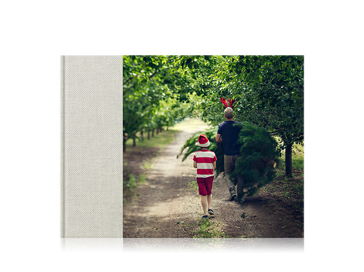 Fotolibro premium in formato orizzontale con 3/4 di copertina di padre e figlio nella foresta.