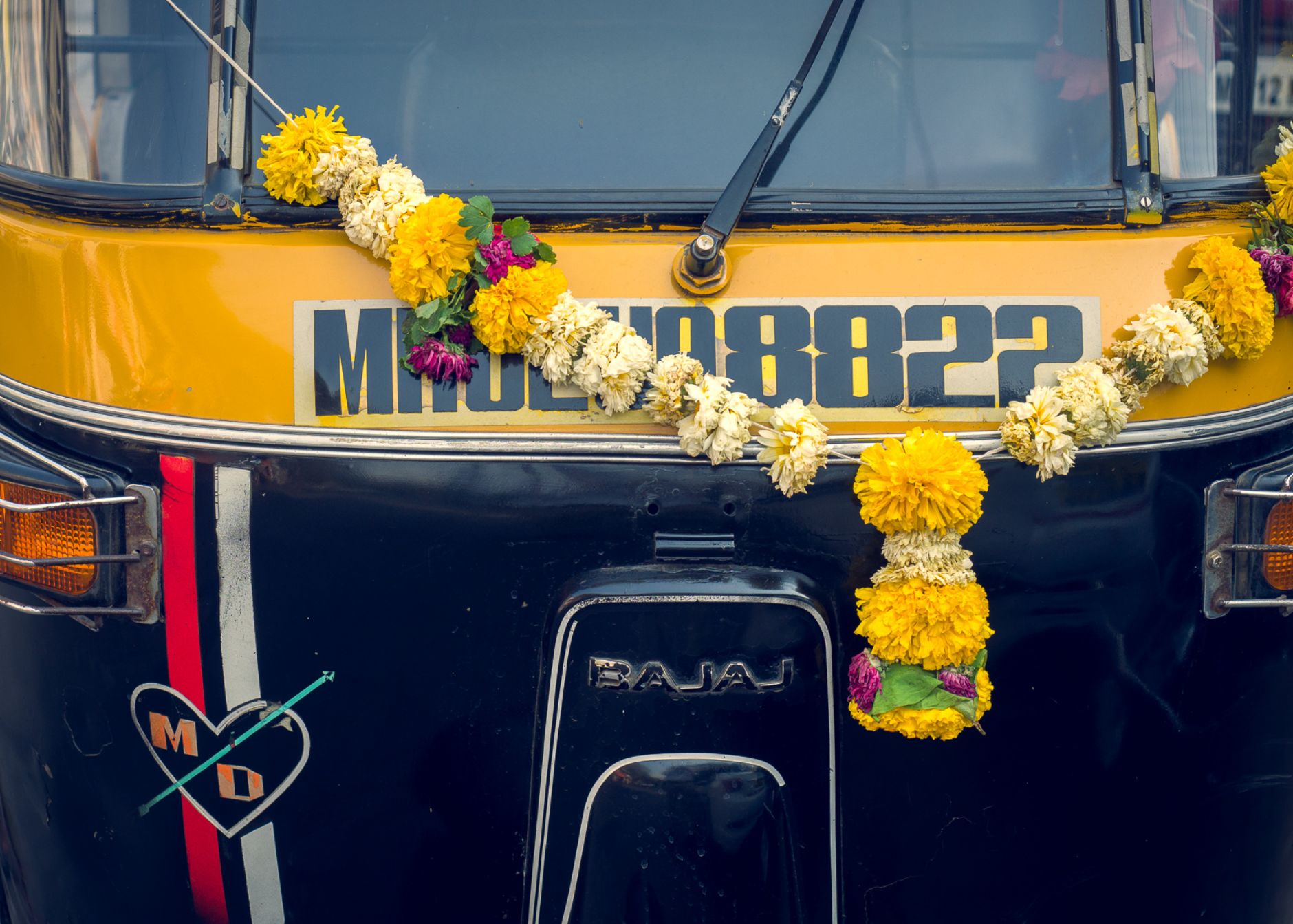 Closeup of vehicle windscreen with floral arrangement.