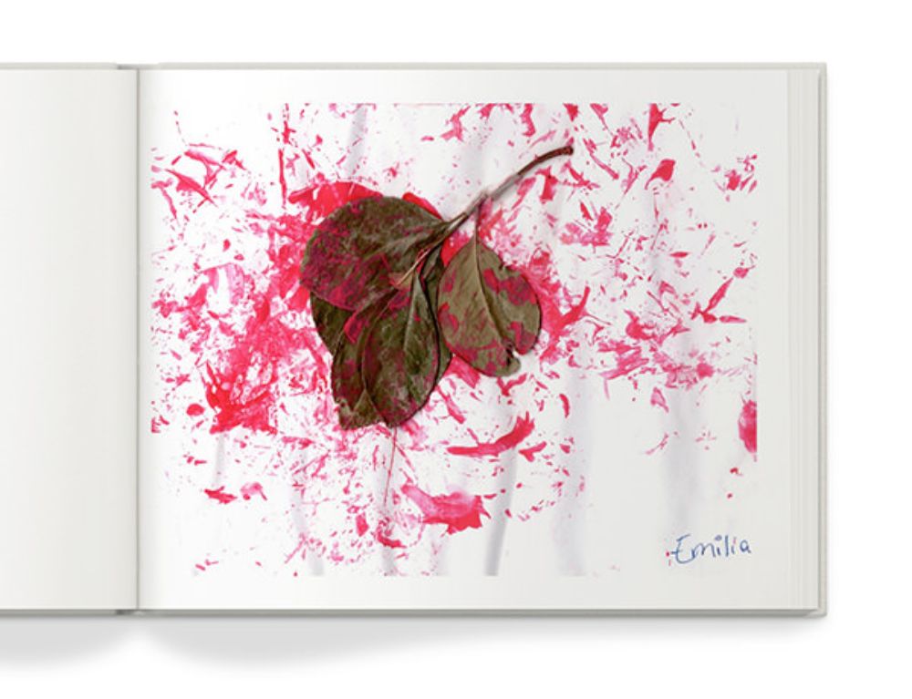 Open photo book with image of child's artwork.