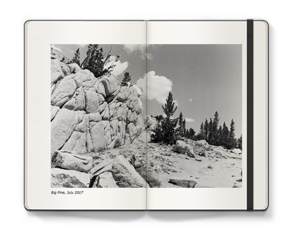 Open Moleskine Photo Book with black and white image of a rocky landscape.