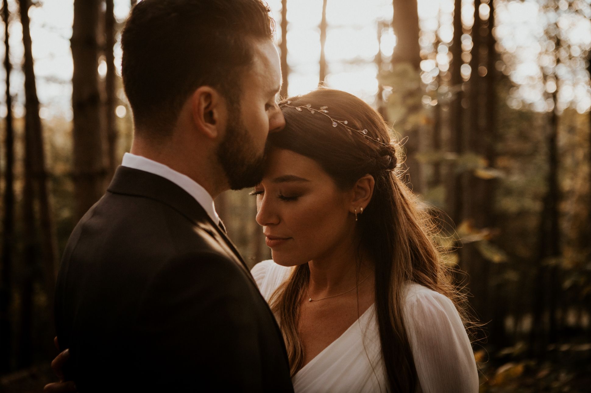Groom kissing bride on forehead