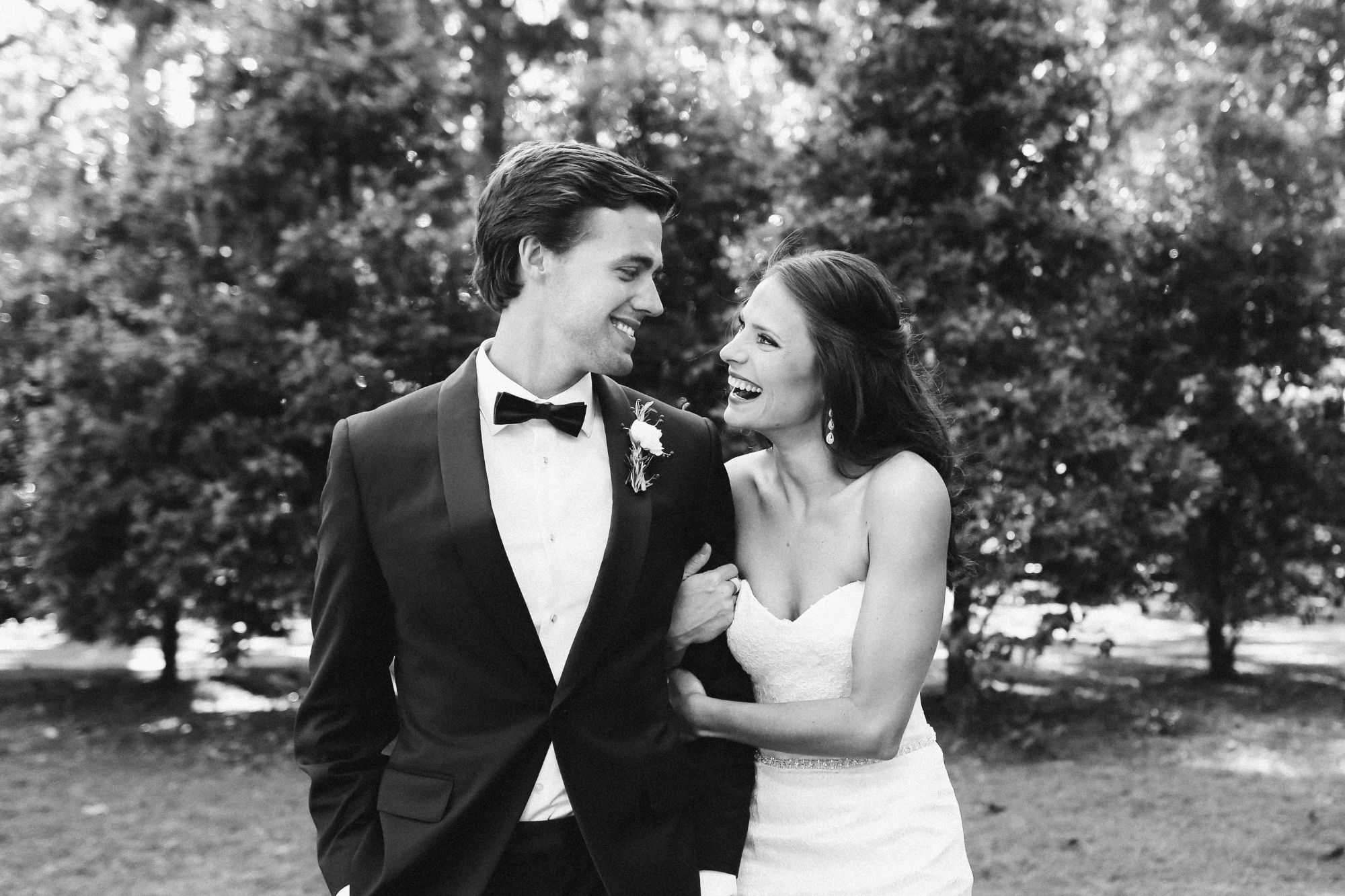 Bride and groom, arm in arm, smiling at each other
