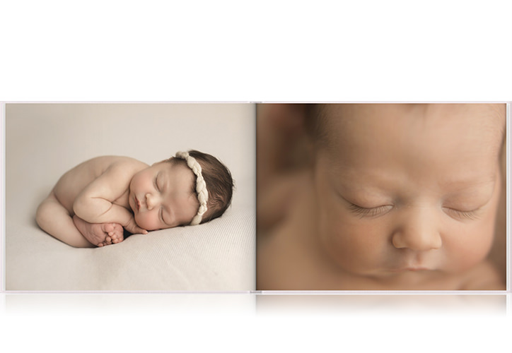 Livro fotográfico de paisagem com duas fotos de um bebê dormindo.