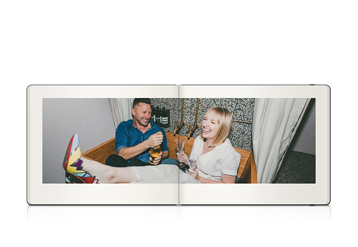 Moleskine photo book showing engaged couple laughing and toasting each other