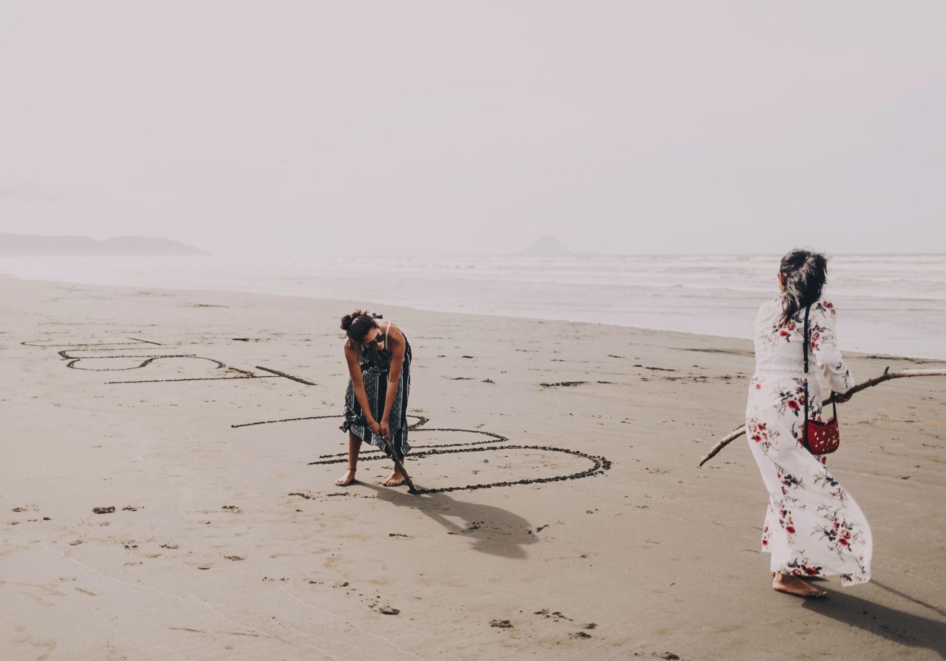 Wedding guests writing Just Married in the sand