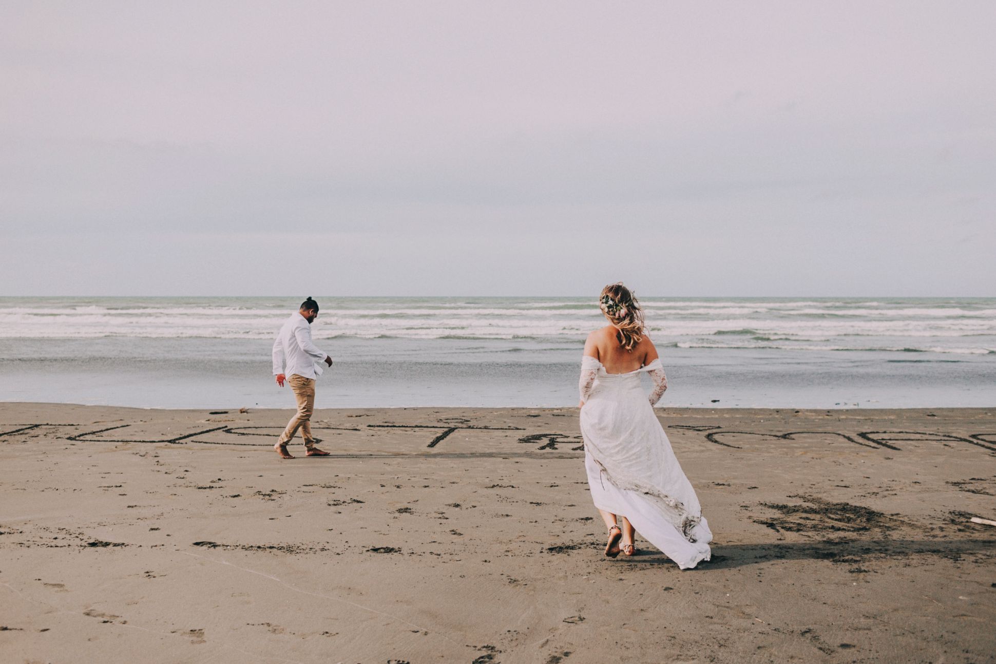 Bride and groom barefoot on the beach