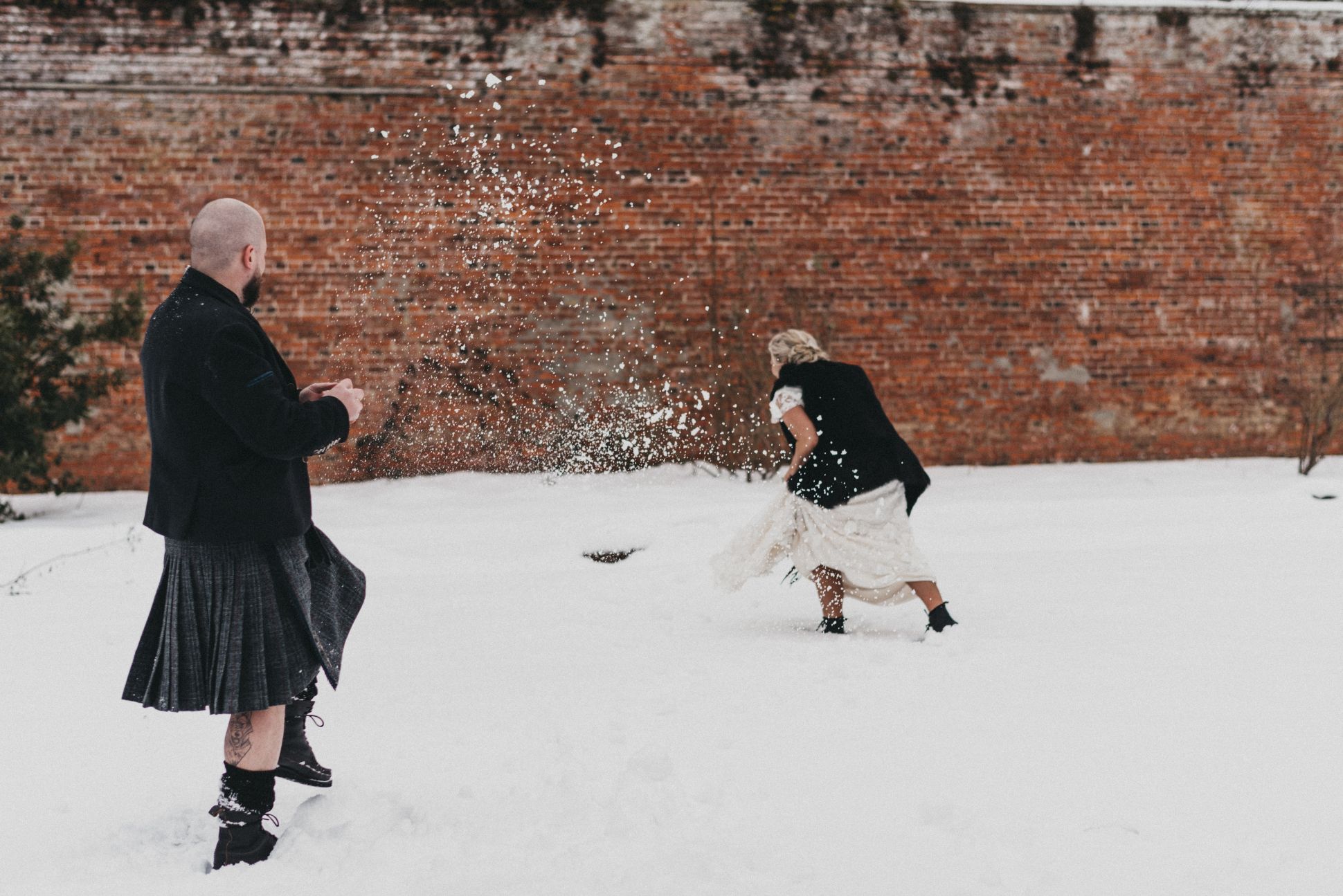 Bride and groom playing in snow