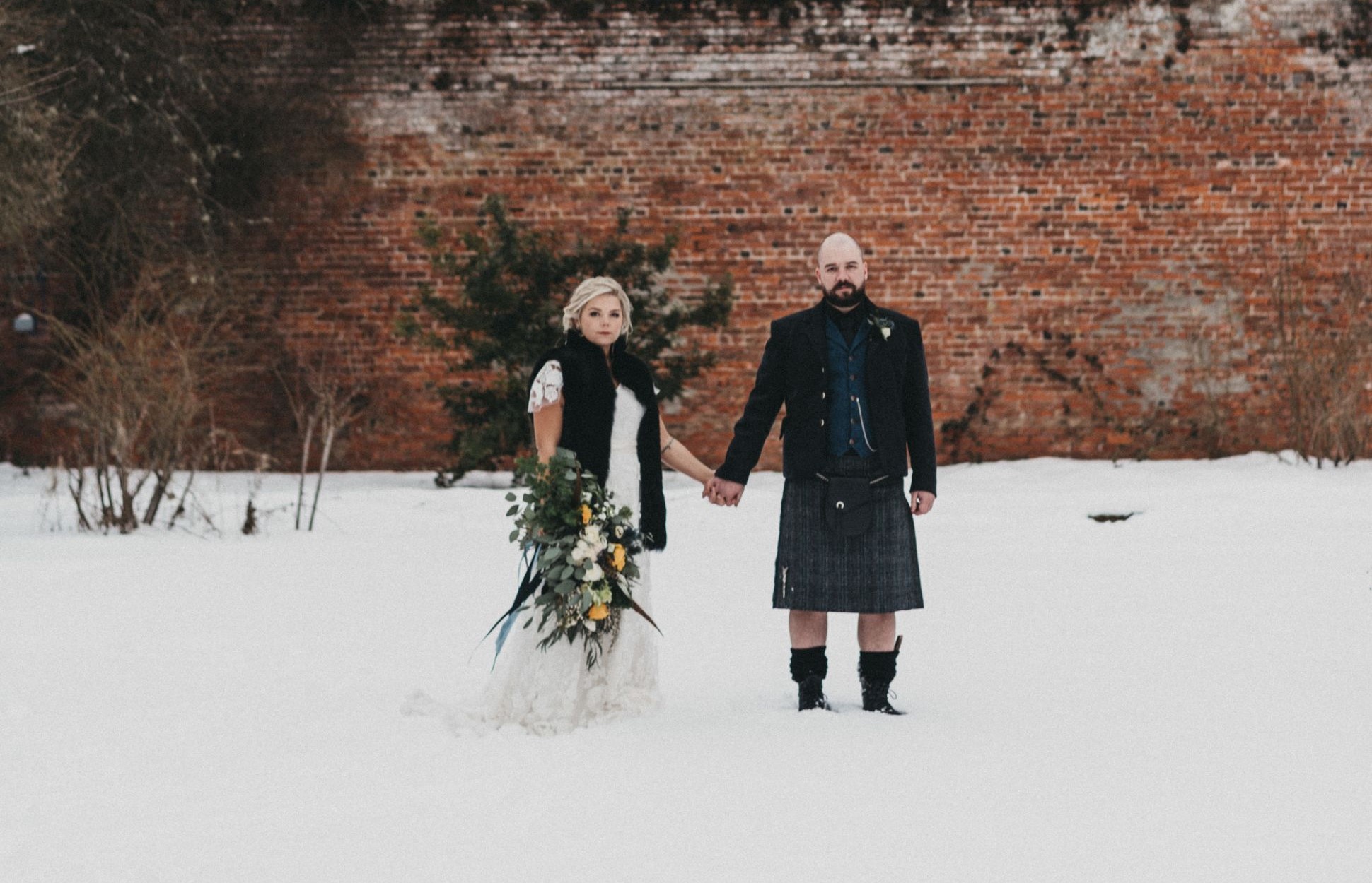 Bride and groom holding hands in snow