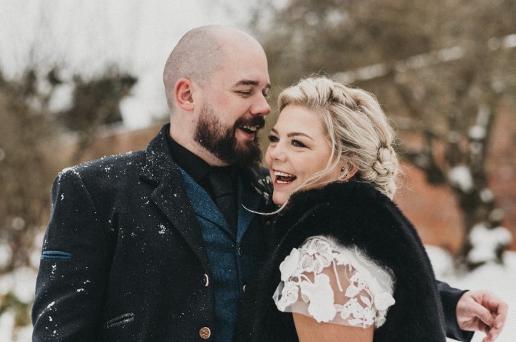 Newlyweds smiling in snow
