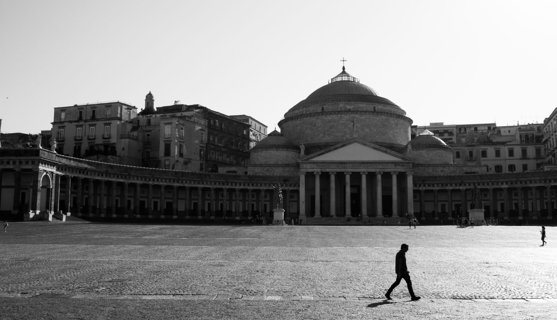 Person walking by Piazza del Plebiscito, Naples, Italy