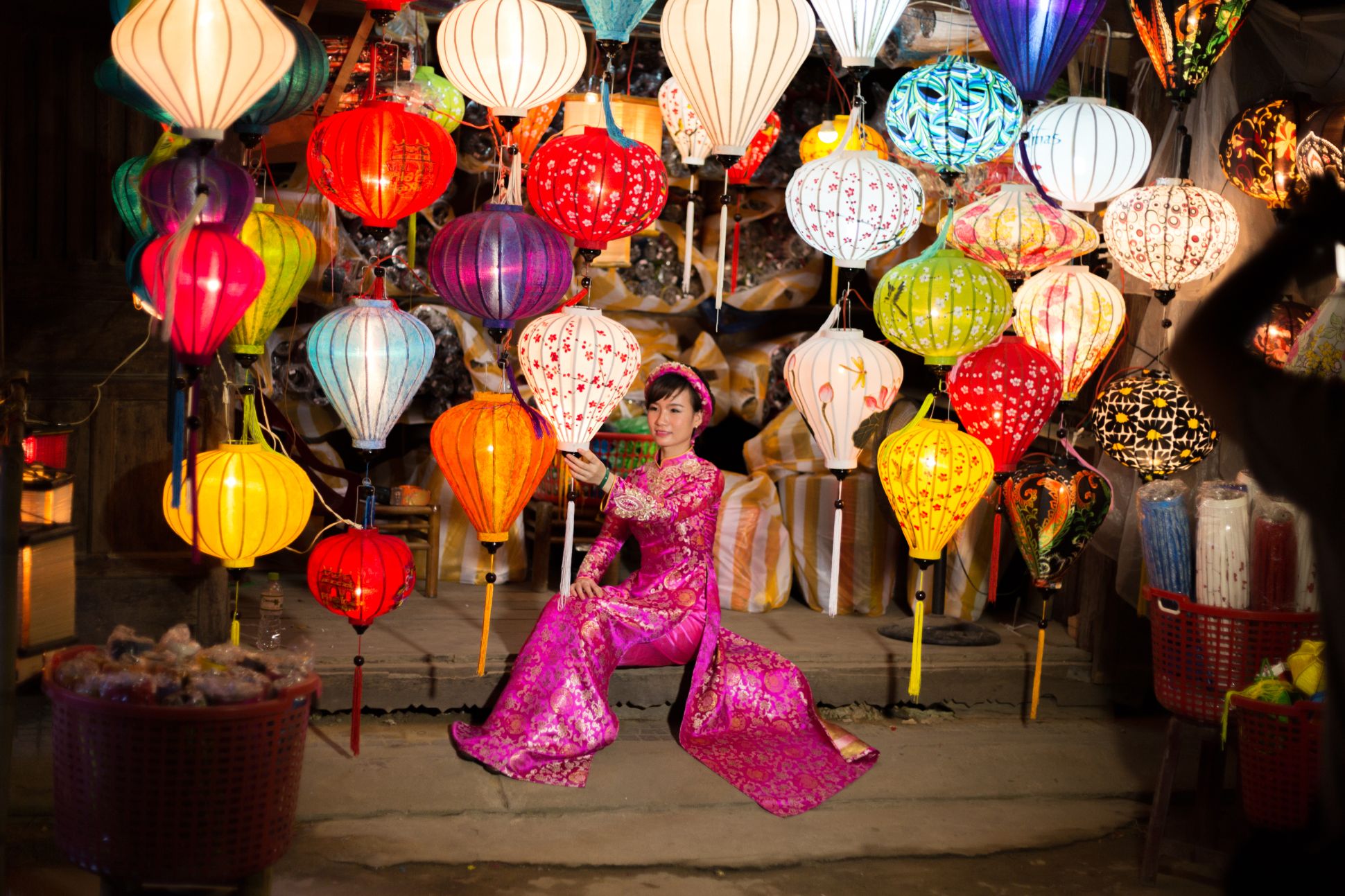Seated woman surrounded by colorful and patterned lanterns