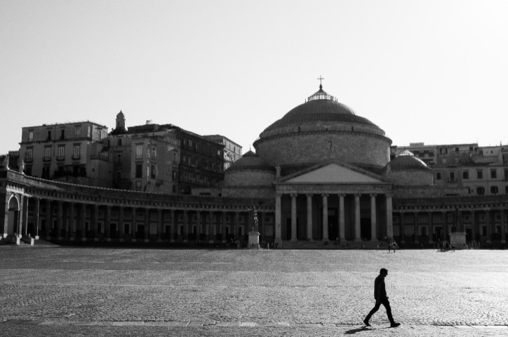 Person walking by Piazza del Plebiscito, Naples, Italy