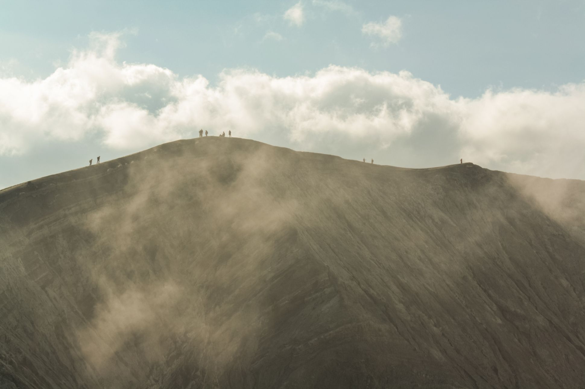 People at the top of a mountain among the clouds.