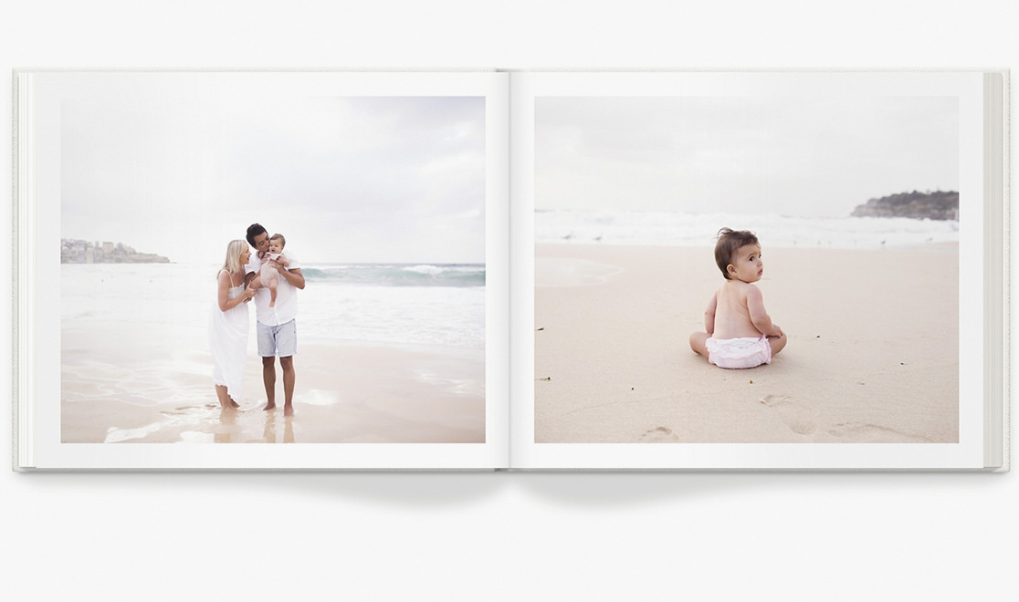 Open photo book with images of family at the beach.