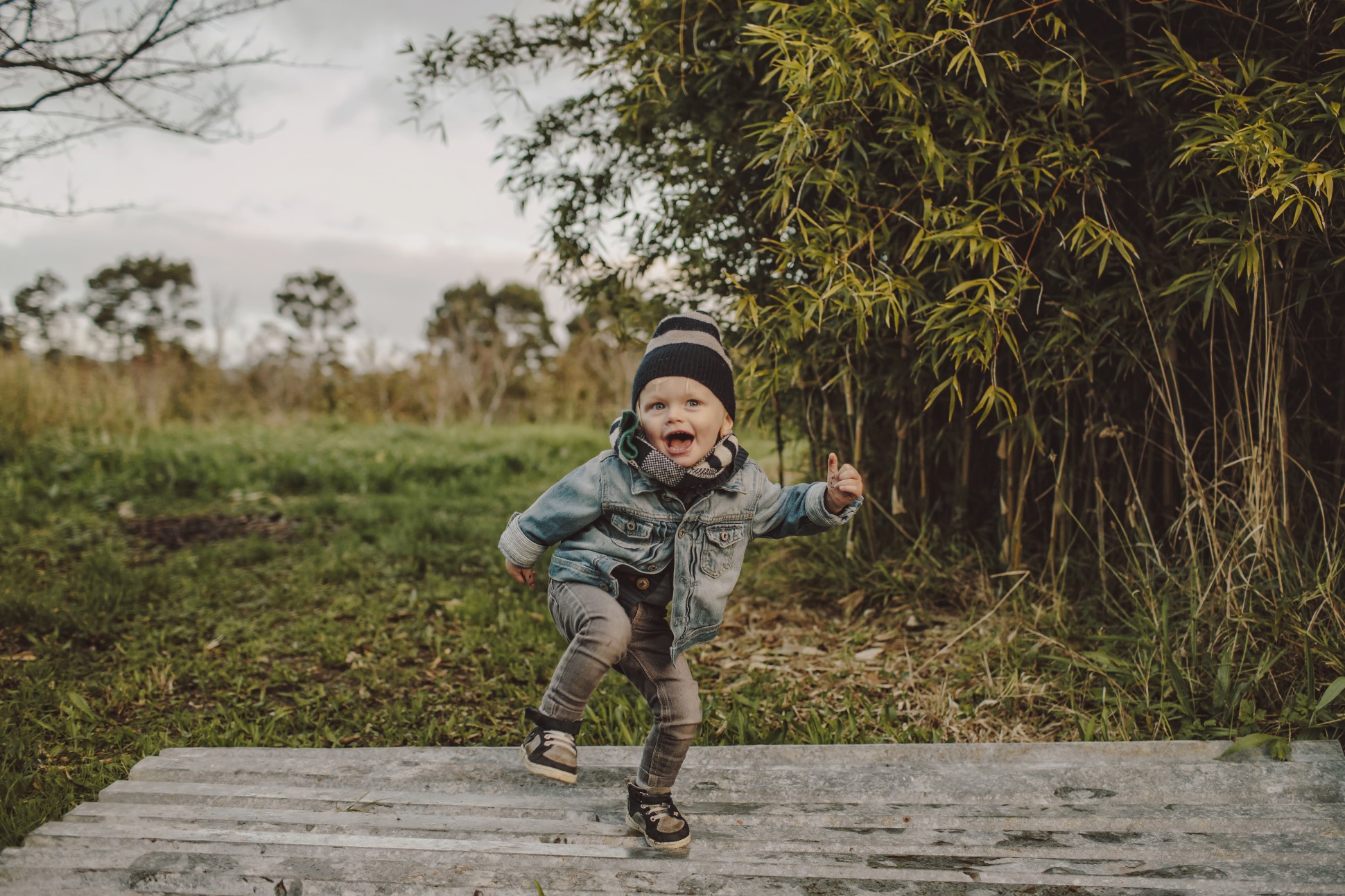 Young child smiling and posing outside.