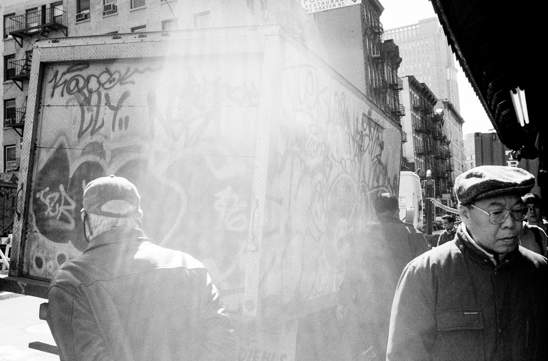 Graffiti-ed truck and people in busy street