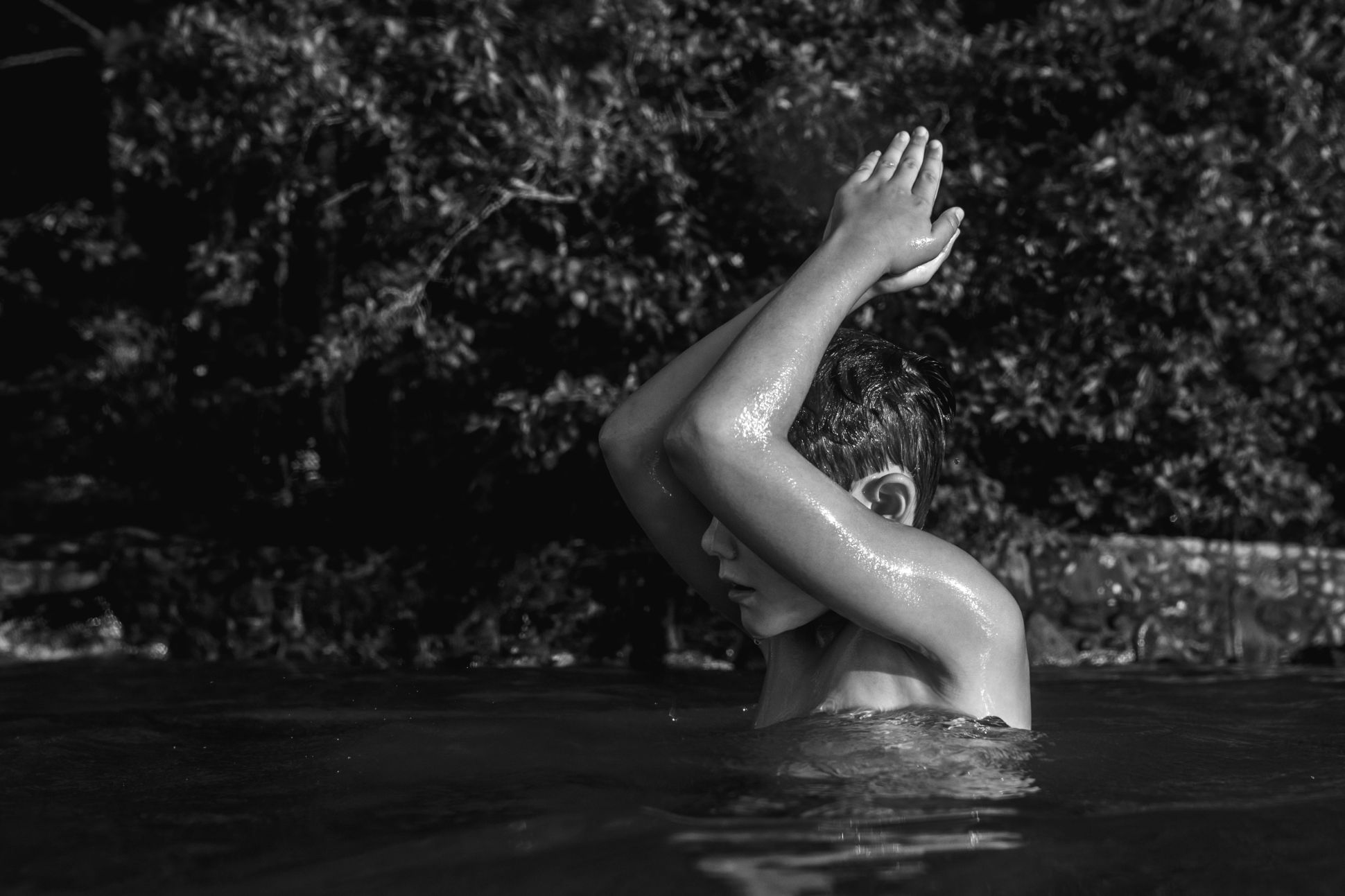 Black and white image of child swimming.