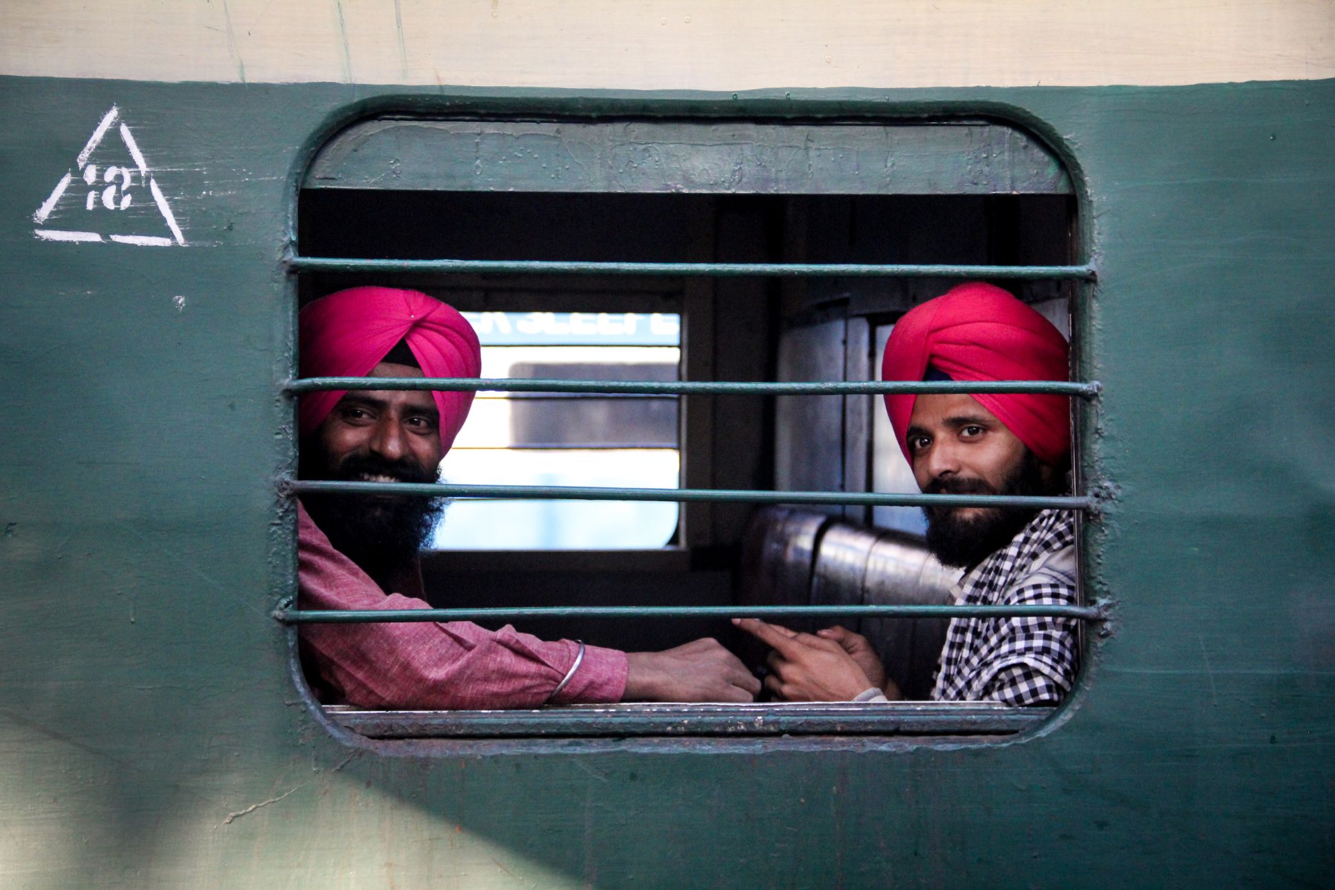 Two men looking out from train